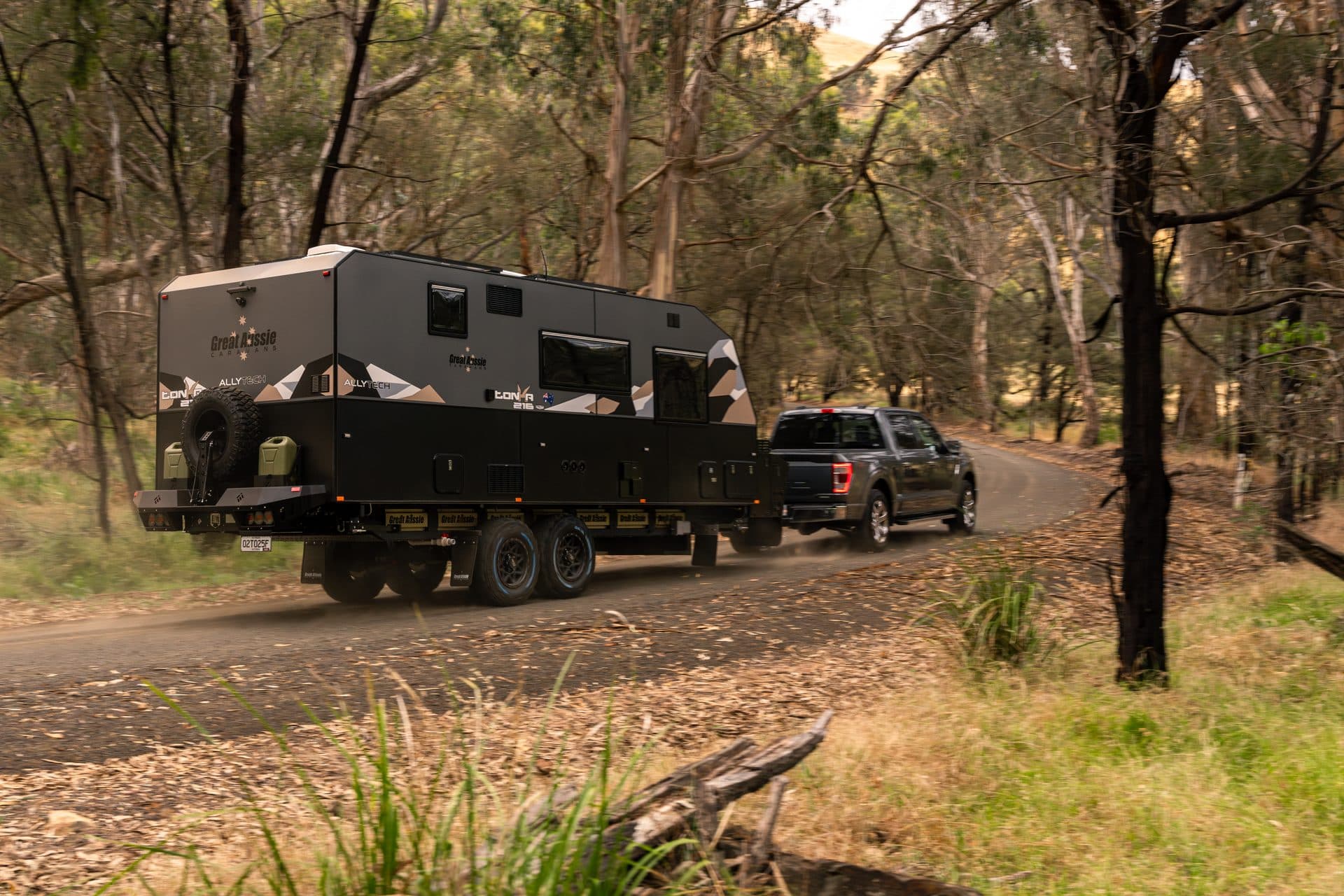 An off-road caravan being towed along a bush track