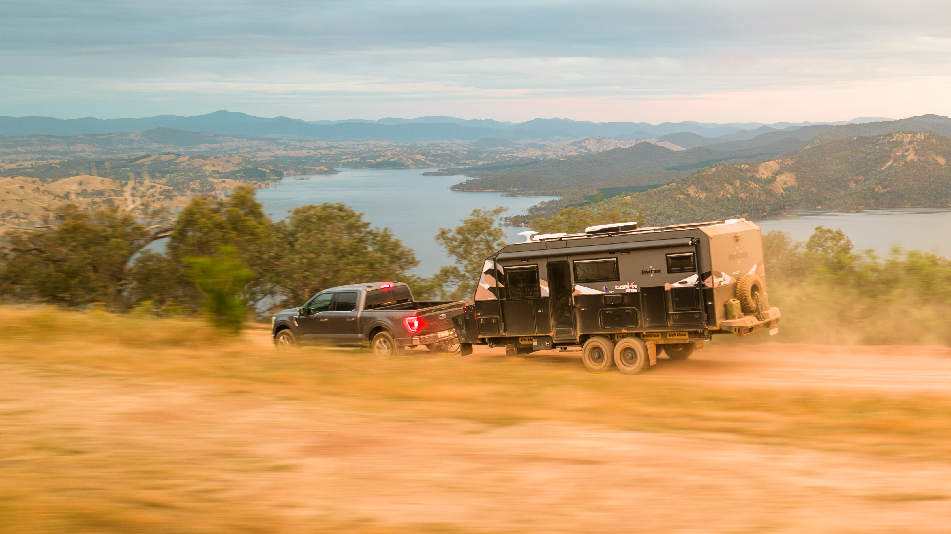 Great Aussie caravan towed through Australian outback with lake panorama